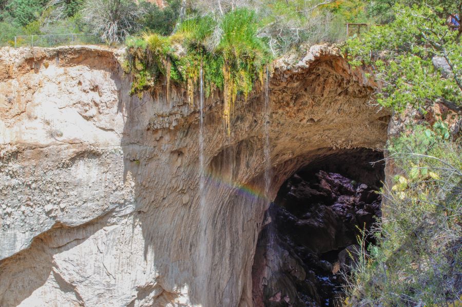 Water falling from a cliff refracts color to create a little rainbow.