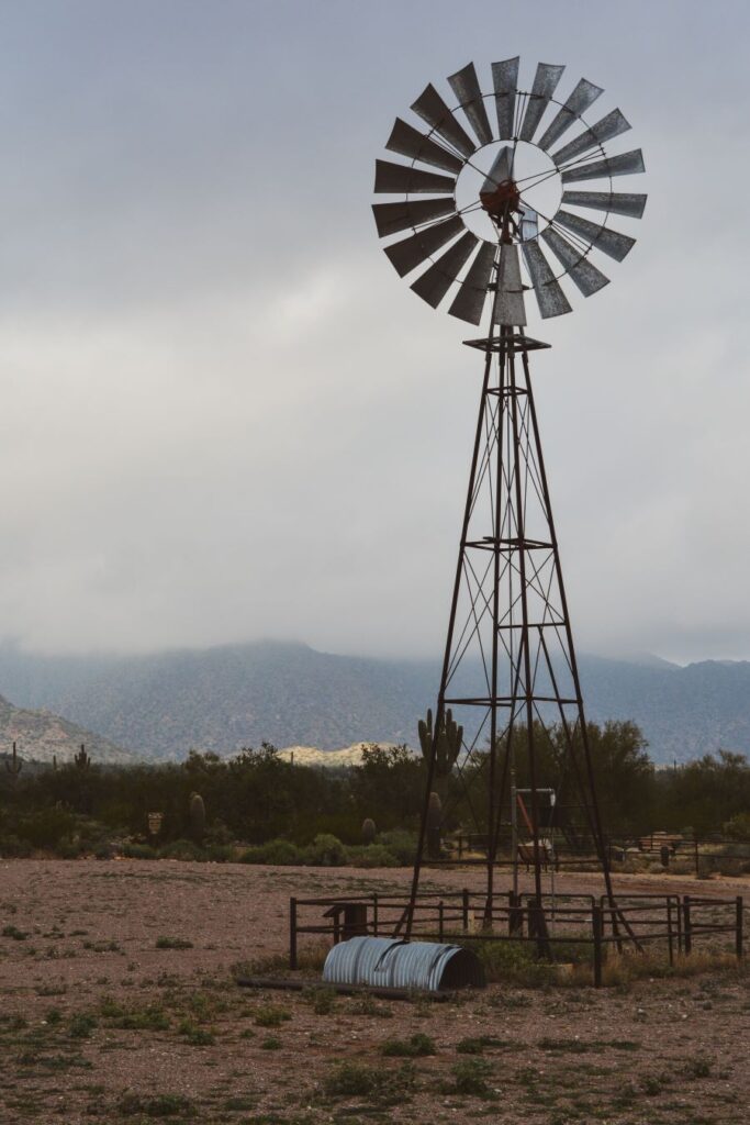 A lone windmill sitting in the expanse of the desert.